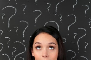 Woman with question marks on a blackboard