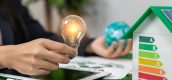 Energielabel huisje met iemand die een lamp en wereldbol vasthoudt