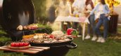 barbecue met eten erop en mensen op de achtergrond