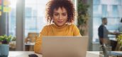 een vrouw die op de laptop zit