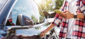 Man bij auto met mobiel